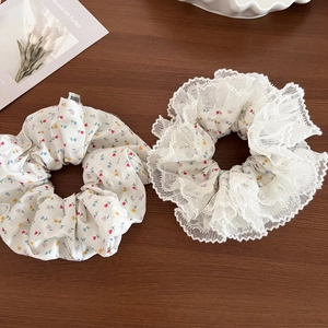 Close-up of floral scrunchies with delicate lace edges on a rustic wooden background