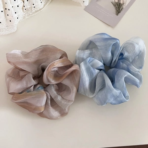 Detail of two-piece ink wash organza scrunchies with pearlescent finish and marble texture