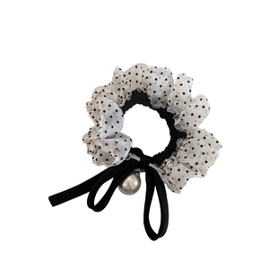 Polka dot mesh scrunchie with black bow and pearl pendant on a white background