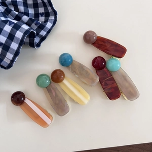 Detailed view of assorted marble pattern acetate hair clips with golden metal clips