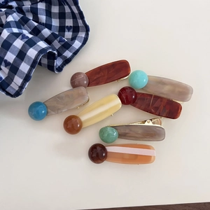 Ink marble resin hair clips with colorful bead accents shown on minimalist background