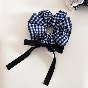 Detail of navy gingham hair scrunchie with blue hearts and a long black satin bow