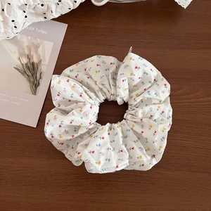 Floral print oversized scrunchie with lace trim on a rustic wood background