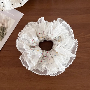 Detail of floral scrunchie with lace edges on a wooden surface with a tulip card