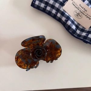 Detailed macro view of vintage acetate hair claw with brown tortoiseshell rose design