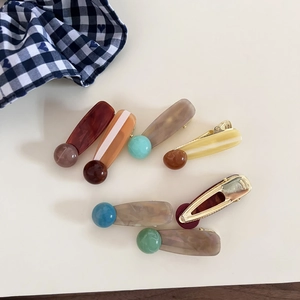 Close-up of Korean style acetate marble hair clips with colorful bead accents