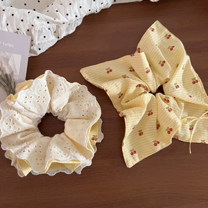 Detail of yellow plaid cherry print scrunchie and white embroidery lace hair tie set