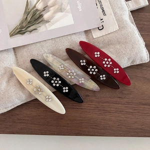 Detail view of five vintage acetate floral hair clips with sparkling rhinestones set