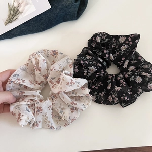 Detailed macro view of two floral scrunchies made of soft chiffon for hair styling