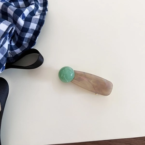 Detail of vintage style hair clip with green marble bead and amber ink wash pattern