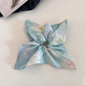 Detail of silk-like blue watercolor bow scrunchie with elegant pearlescent finish