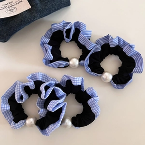 Detail of four vintage blue striped and plaid hair scrunchies with white pearl accents