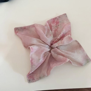 Detail of pink floral chiffon scrunchie with soft translucent fabric and flower design