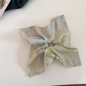 Macro view of artistic ink-wash print on translucent chiffon fabric hair scrunchie