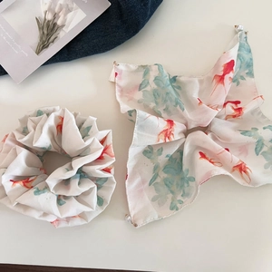 Detailed close-up of a chiffon scrunchie and scarf set with goldfish and pearl accents
