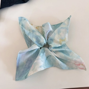 Detail view of large silk-textured hair scrunchie with blue marble watercolor print