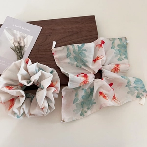 Detailed view of goldfish ink painting hair scrunchies with elegant tassels and pearls