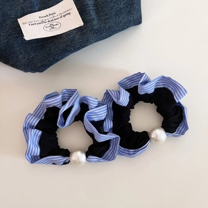 Close-up of two blue striped elastic hair scrunchies with large pearl embellishments