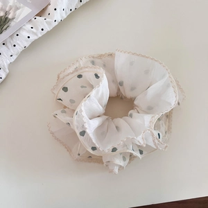 Detail of cream chiffon scrunchie with blue heart polka dots and delicate lace edges