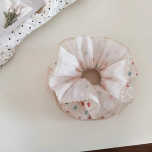 Detail of sweet chiffon scrunchie with colorful heart patterns and lace edging design