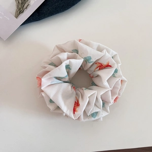 Macro detail of ink-wash red goldfish pattern scrunchie with fine fabric texture