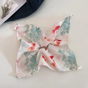 Detail of silk hair scarf featuring red goldfish prints and pearl tassel corners