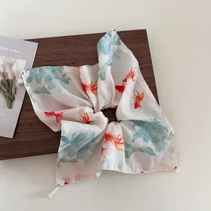 Detailed view of chiffon scrunchie with red goldfish ink painting and pearl tassel