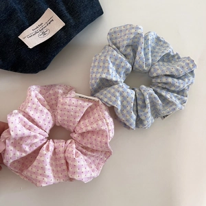 Detail of pink and blue plaid scrunchies with red polka dots and soft cotton texture