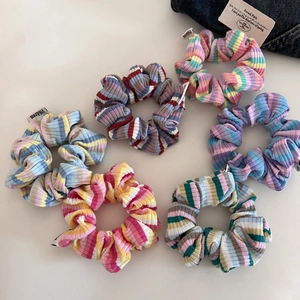 Flat lay of six colorful knitted striped scrunchies set with soft pastel macaron colors