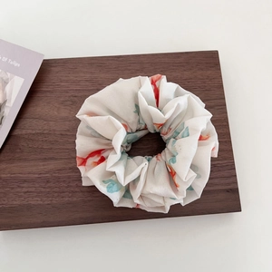 Elegant white scrunchie with red and blue watercolor goldfish prints on wood