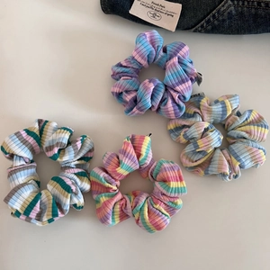 Set of four vibrant rainbow striped knit scrunchies for ponytail styling and hair accessories