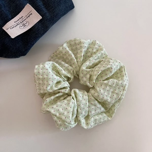 Close-up of sweet light green plaid and purple polka dot fabric hair scrunchie texture