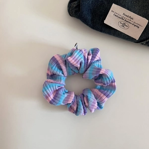 Close-up of vibrant striped knit fabric texture on a soft oversized hair scrunchie