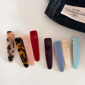 Flat lay of handmade acetate drop hair clips set in diverse colors and retro patterns