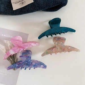 Detail view of large acetate claw clips in marble and ink patterns with four color options