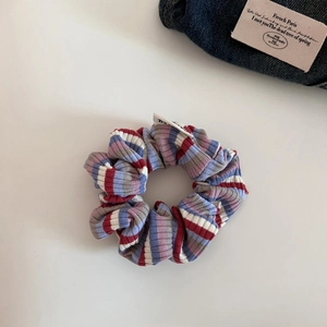 Detail of colorful striped hair scrunchie with ribbed texture and white brand label