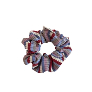 Colorful striped knit scrunchie with ribbed texture and white label for hair styling