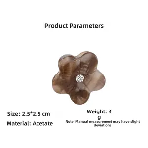 Detail view of mini amber acetate flower hair claw clip with crystal center 2.5x2.5cm