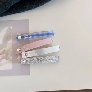 Set of four stylish acetate hair clips featuring heart motifs and assorted color finishes