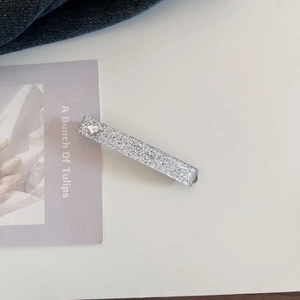 Close-up of silver glitter hair clip with hot mood text and small heart detail