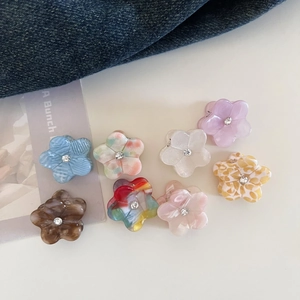 Mini floral acetate hair claws set with rhinestones on stylish denim background