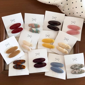 Retro acetate oval hair clips set in various marble patterns on white display cards