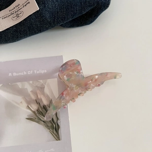 Close-up of handmade tortoiseshell acetate claw clip with delicate floral marble patterns