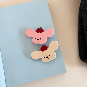 Dettaglio di graziose clip per capelli in acetato a forma di cucciolo rosa e beige