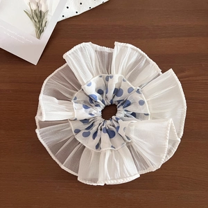 Macro view of blue polka dot lace scrunchie with layered white pleated tulle fabric