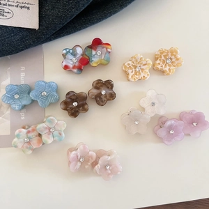 Close-up of assorted floral acetate mini hair claws with rhinestone center detail