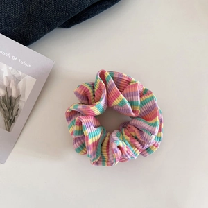 Detailaufnahme eines bunten, regenbogenfarbenen gestrickten Haargummis mit Rippstruktur