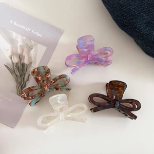 Detailed set of four acetate bow hair claws featuring marble and tortoiseshell patterns