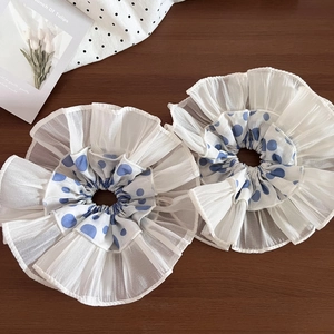 Detail of blue polka dot lace chiffon scrunchies set with layered pleats on wood surface
