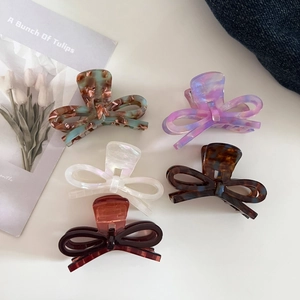 Detailed close-up of 5-piece acetate bow hair claws in tortoiseshell and marble textures